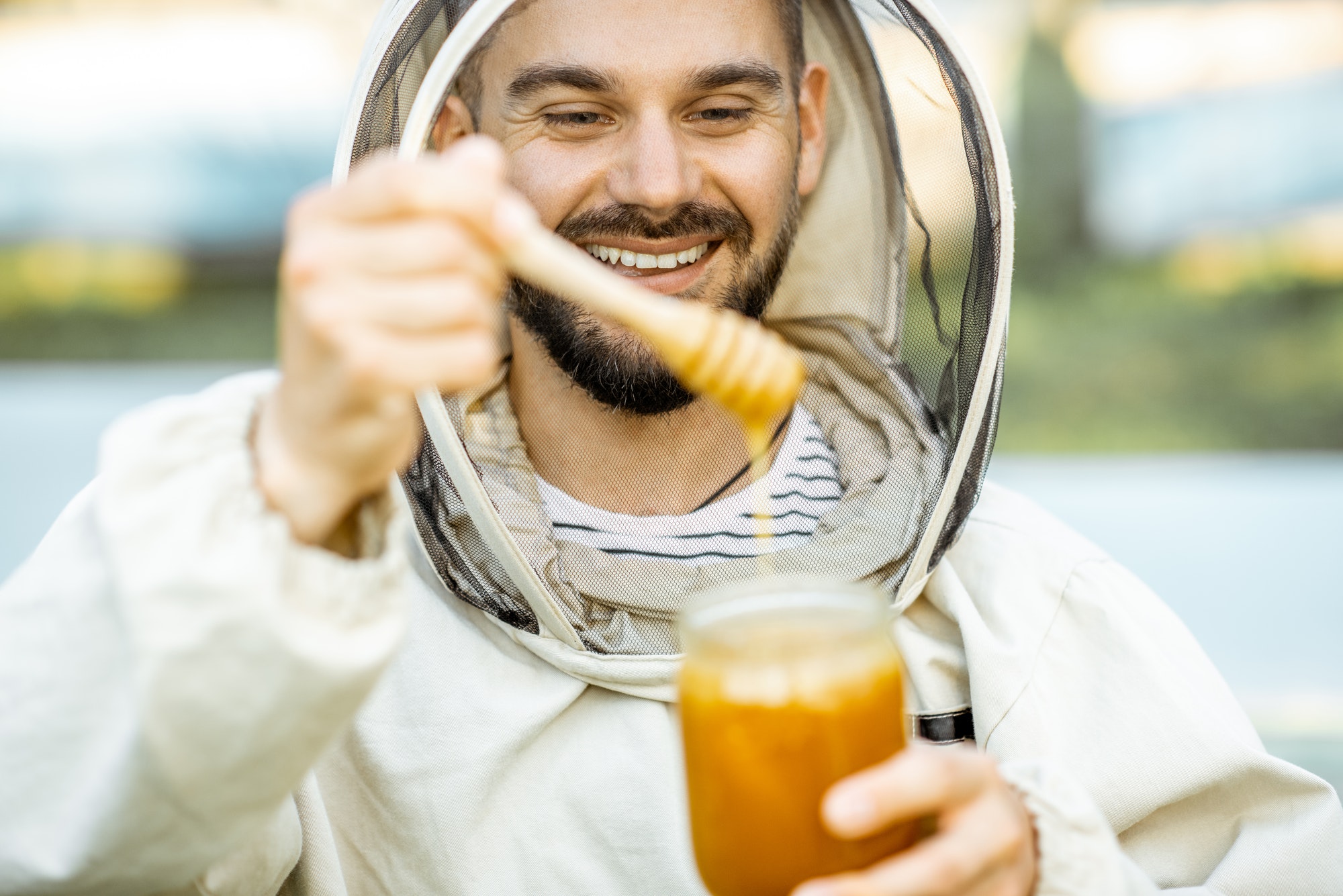 Beekeeper with honey on the apiary